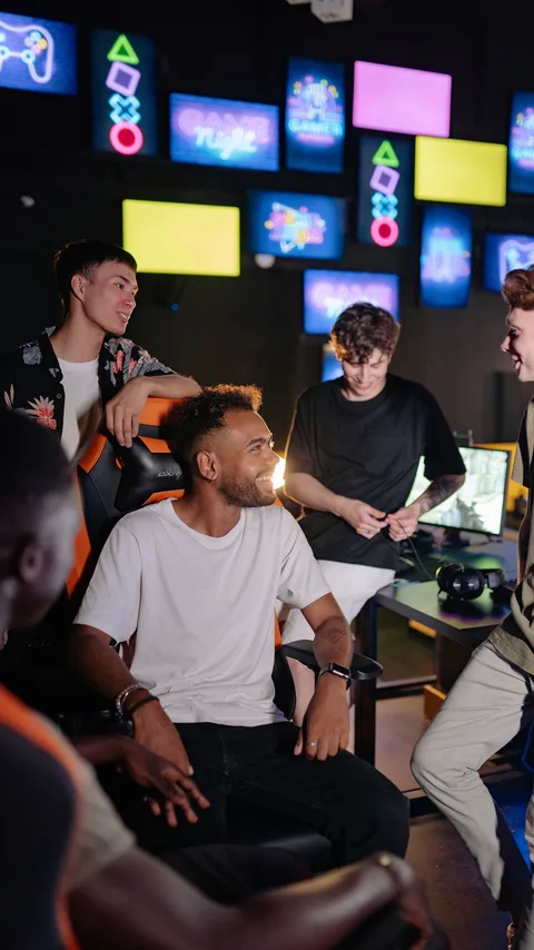 A group of gamers gathered around a desk mid-conversation in a gaming space